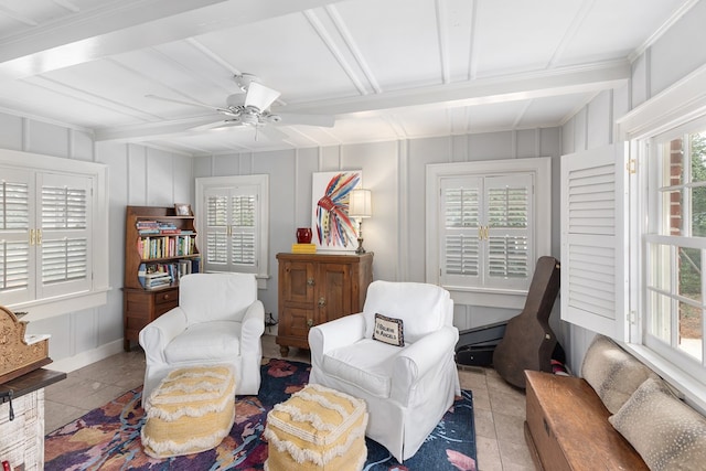 sitting room with plenty of natural light, tile patterned flooring, and a decorative wall