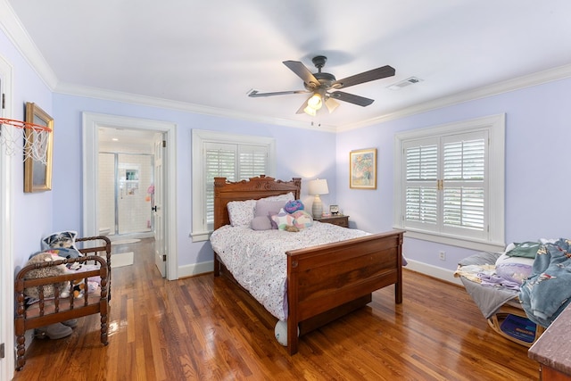 bedroom with crown molding, visible vents, ensuite bathroom, wood finished floors, and baseboards