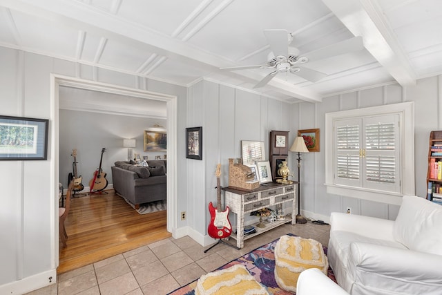 tiled living area featuring ceiling fan, beamed ceiling, and baseboards