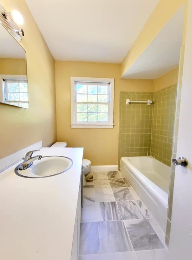 full bathroom with baseboards, vanity, toilet, and shower / bath combination