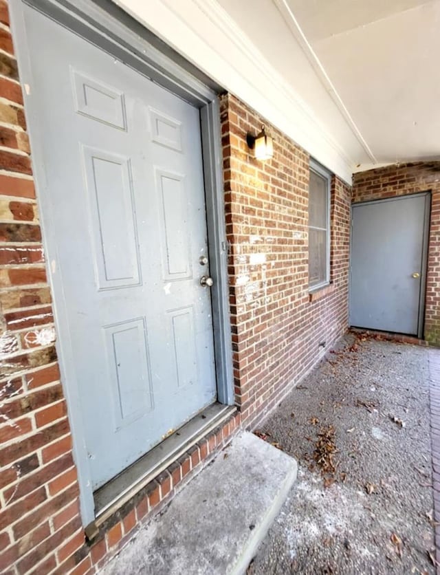 entrance to property featuring brick siding