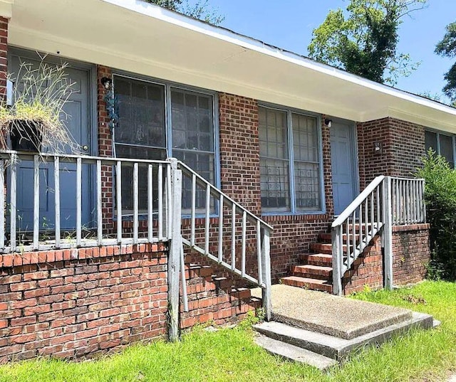 view of exterior entry featuring brick siding