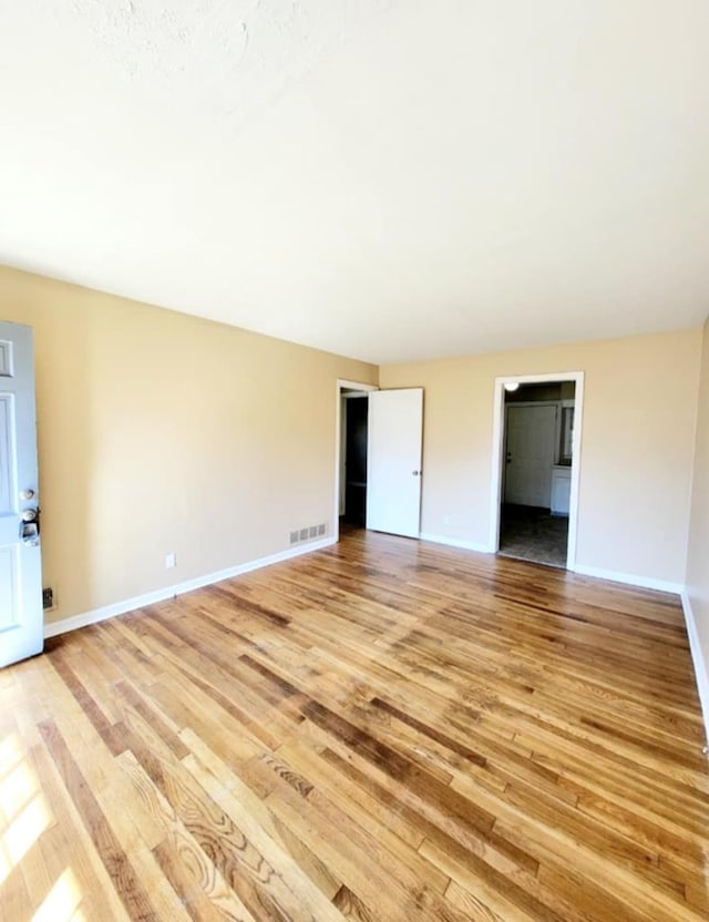 interior space featuring baseboards, visible vents, and light wood-style flooring