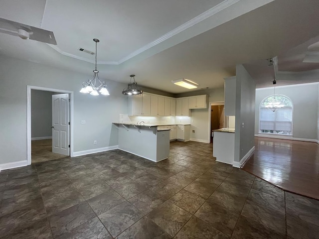 kitchen featuring visible vents, baseboards, a tray ceiling, a peninsula, and white cabinetry