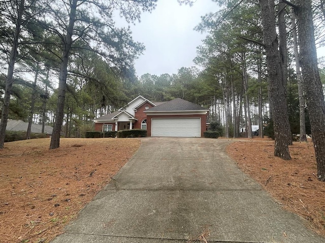 view of front of house with concrete driveway, brick siding, and a garage