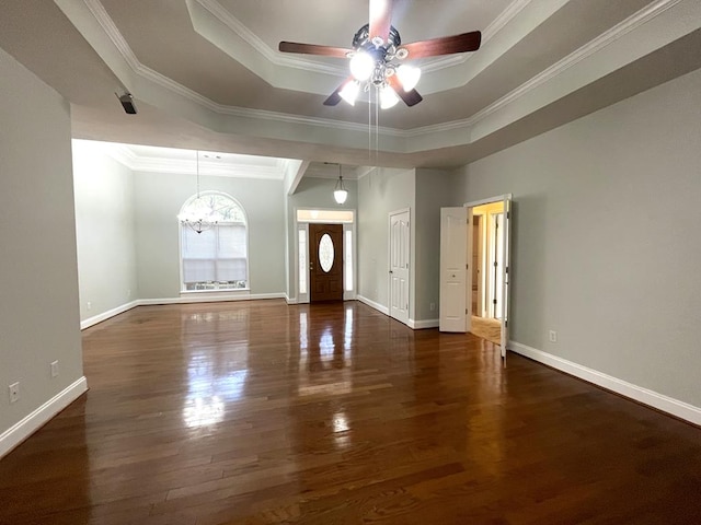 interior space with baseboards, a raised ceiling, wood finished floors, and ornamental molding