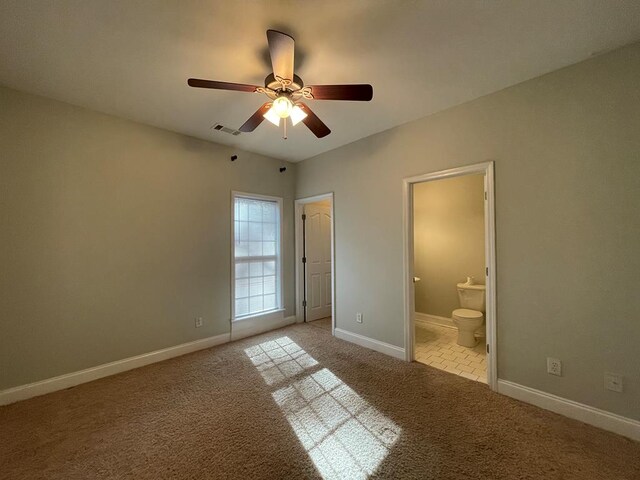 empty room with a ceiling fan, carpet flooring, baseboards, and visible vents