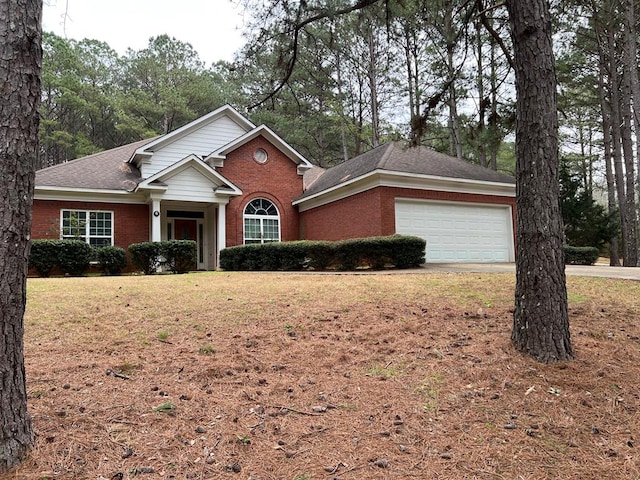 view of front of house with brick siding, driveway, a front lawn, and a garage