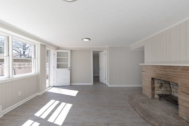 unfurnished living room featuring a fireplace, wood finished floors, and baseboards