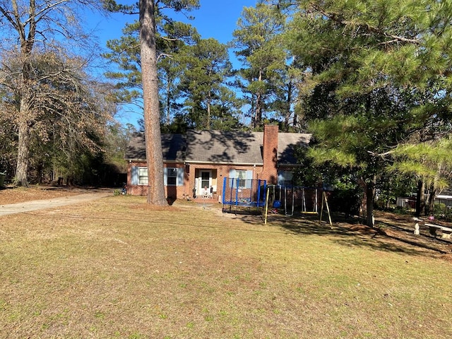 view of front of property featuring a front yard and a trampoline