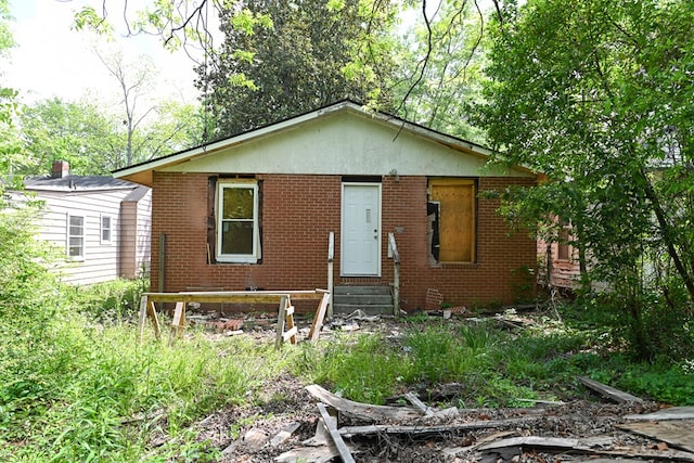 bungalow-style home featuring entry steps and brick siding