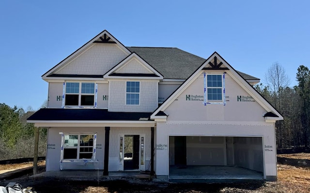 property in mid-construction featuring covered porch, a garage, and driveway