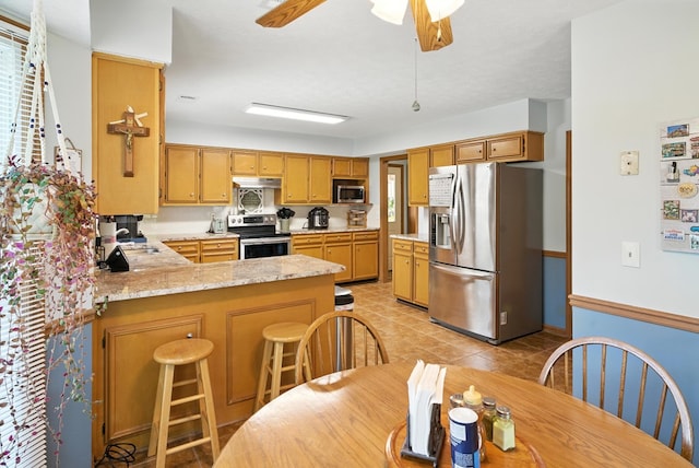 8500 Jackson Rd, Midland, GA 31820 - kitchen featuring appliances with stainless steel finishes, a peninsula, healthy amount of natural light, and light tile patterned floors