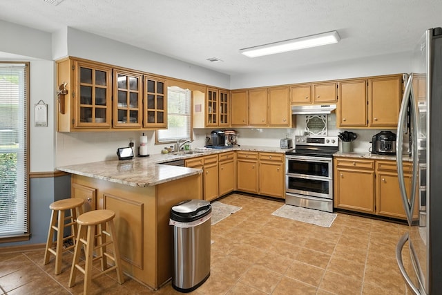 8500 Jackson Rd, Midland, GA 31820 - kitchen featuring stainless steel appliances, a peninsula, plenty of natural light, glass insert cabinets, and a textured ceiling