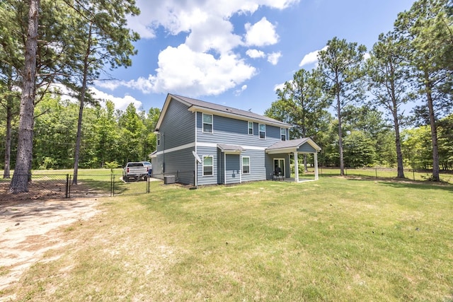 back of property with covered porch and a yard