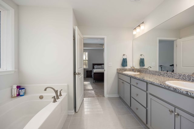 bathroom with ceiling fan, vanity, tile patterned floors, and a bath