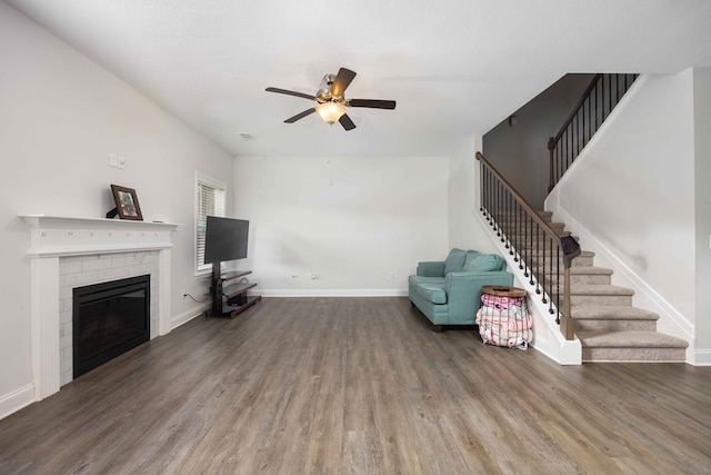 unfurnished living room featuring ceiling fan, a brick fireplace, and hardwood / wood-style floors