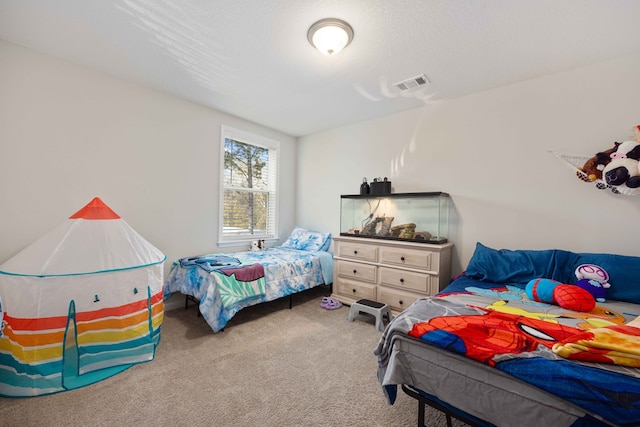 bedroom with light colored carpet and a textured ceiling