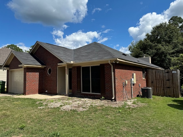 view of front facade featuring a garage, central air condition unit, and a front yard