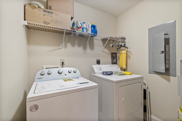 laundry room featuring washer and clothes dryer, a textured ceiling, and electric panel