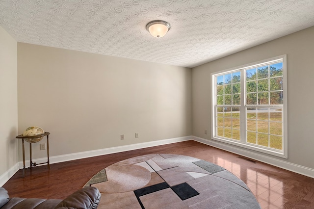 empty room featuring a textured ceiling and hardwood / wood-style flooring