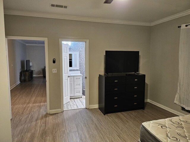 unfurnished bedroom featuring wood-type flooring, ensuite bathroom, ceiling fan, and crown molding