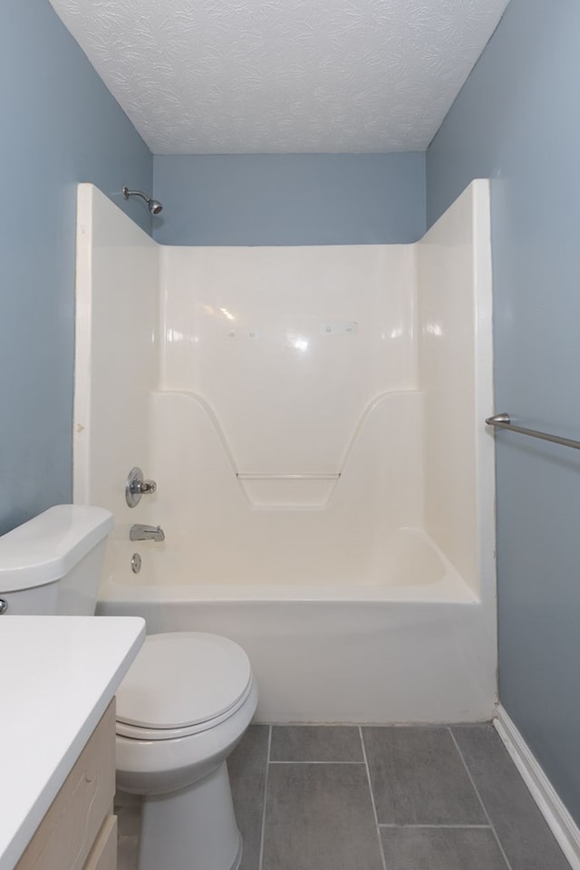 full bathroom featuring a textured ceiling, shower / washtub combination, vanity, and toilet