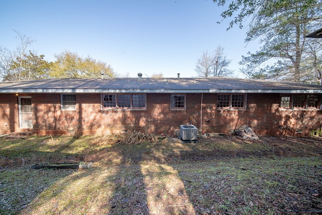 back of house featuring a yard and central AC unit