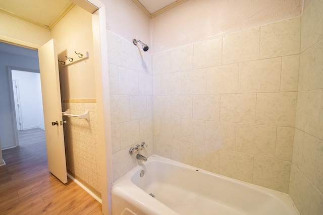 bathroom featuring tile walls, wood-type flooring, and tiled shower / bath