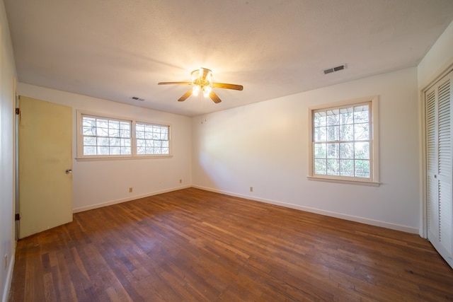 unfurnished bedroom with a closet, a textured ceiling, dark hardwood / wood-style floors, and ceiling fan