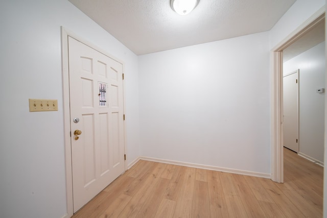 entryway featuring light hardwood / wood-style floors and a textured ceiling