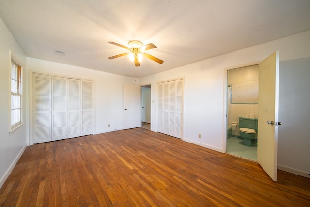 unfurnished bedroom with ceiling fan, connected bathroom, and dark hardwood / wood-style floors