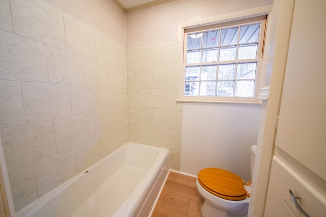 bathroom featuring hardwood / wood-style flooring, toilet, and a tub