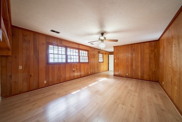 unfurnished room with ceiling fan, ornamental molding, a textured ceiling, and light wood-type flooring