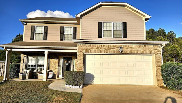 traditional home featuring concrete driveway, a garage, a front lawn, and brick siding