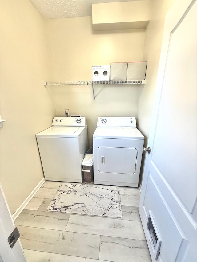 laundry room featuring laundry area, visible vents, baseboards, independent washer and dryer, and light wood-style floors