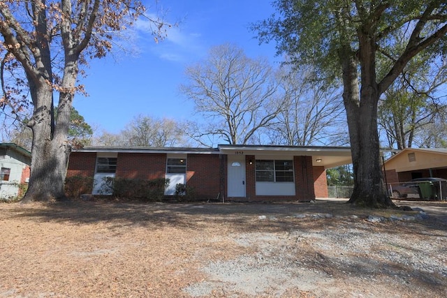 ranch-style house with a carport and brick siding