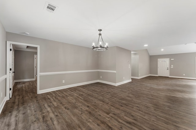 unfurnished room featuring dark hardwood / wood-style floors and a notable chandelier