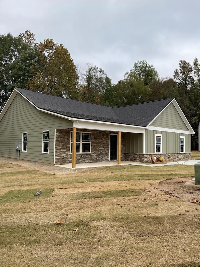 ranch-style house with a front yard and covered porch