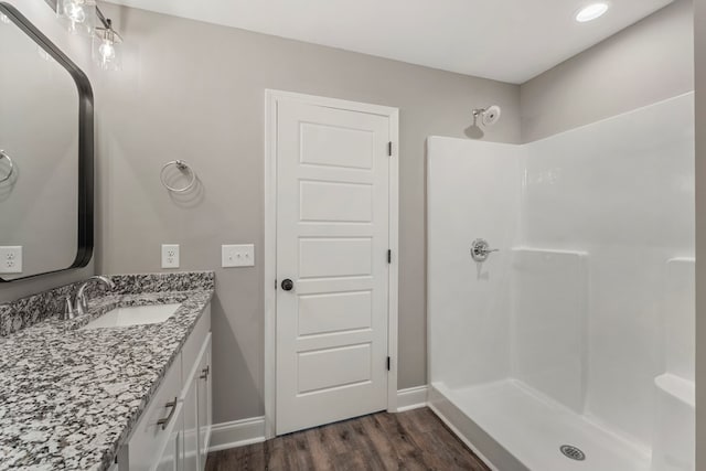 bathroom with vanity, a shower, and wood-type flooring