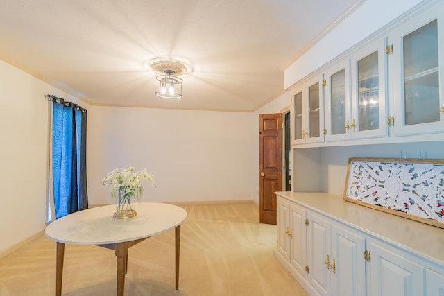 carpeted dining area with ornamental molding