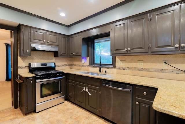 kitchen with sink, light stone counters, decorative backsplash, dark brown cabinets, and appliances with stainless steel finishes