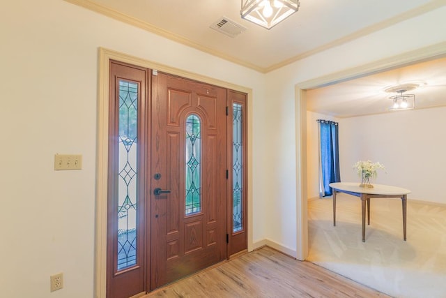 foyer with light hardwood / wood-style flooring and ornamental molding