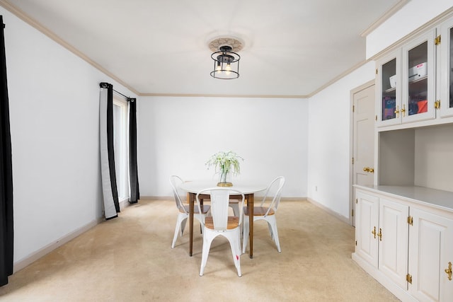 carpeted dining space featuring crown molding