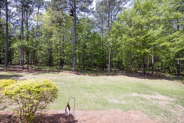 view of yard with a view of trees and fence
