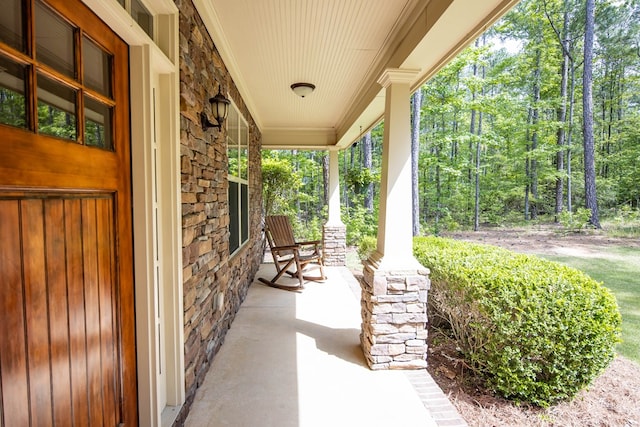 view of patio / terrace with a view of trees and covered porch