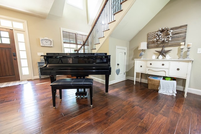 living area with baseboards, a healthy amount of sunlight, wood finished floors, and stairs