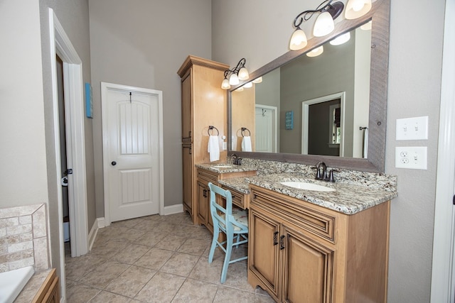 bathroom featuring tile patterned flooring, a towering ceiling, double vanity, a sink, and a bathing tub