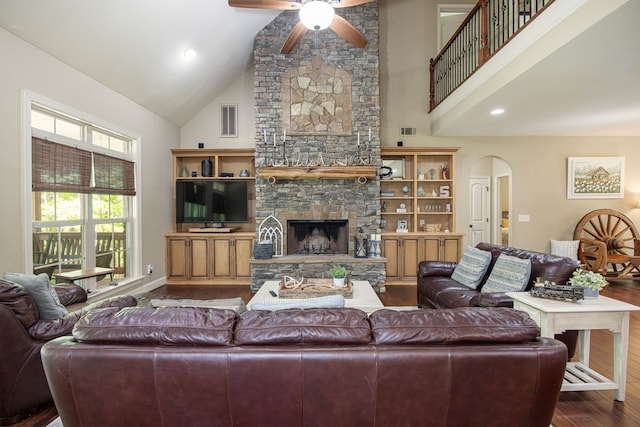 living area with dark wood-style floors, arched walkways, visible vents, ceiling fan, and high vaulted ceiling