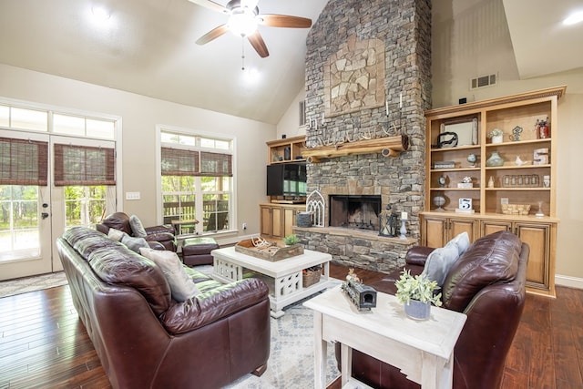 living room featuring high vaulted ceiling, a ceiling fan, a stone fireplace, hardwood / wood-style flooring, and visible vents